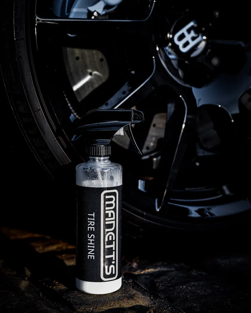 Manetts Tire Shine bottle beside a performance wheel and brake caliper