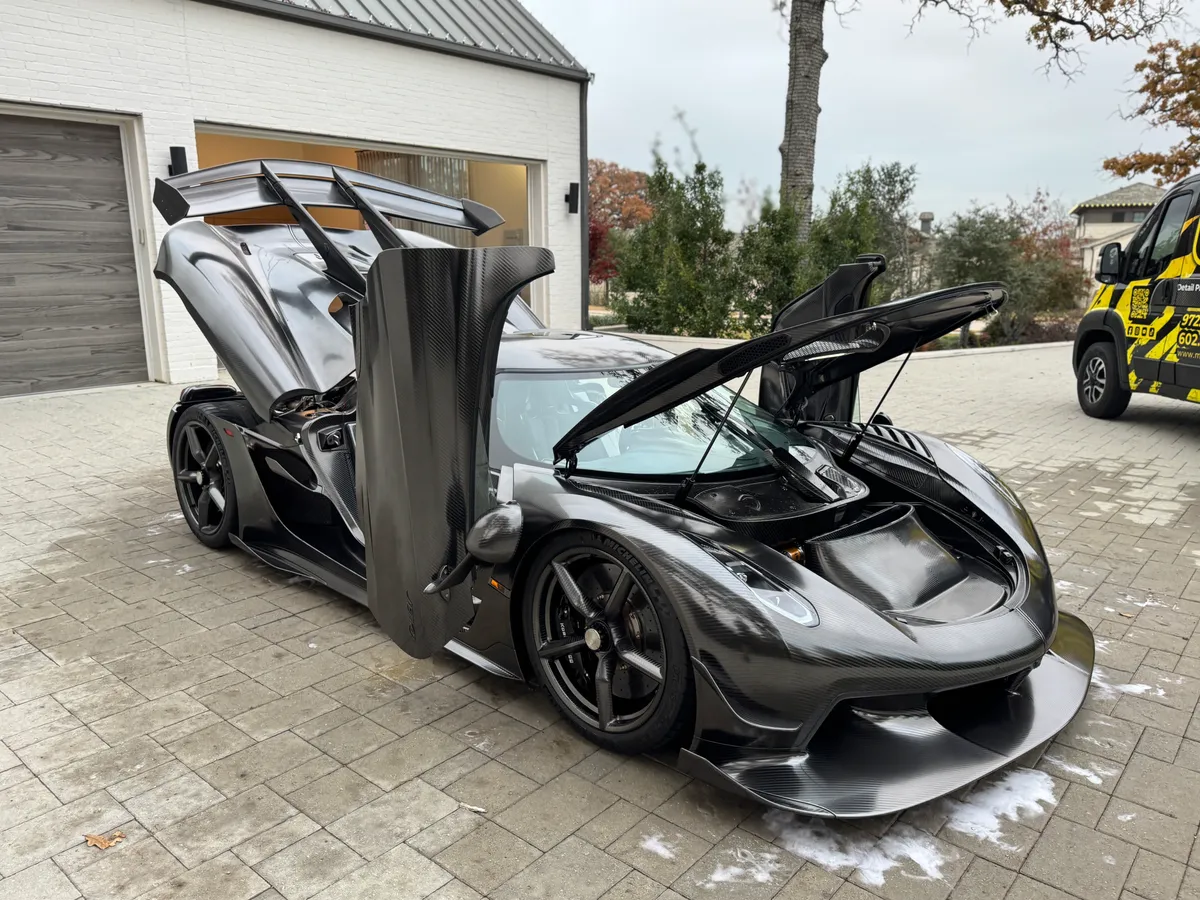 Side view of a black McLaren with doors raised at Protektd Detailing, Dallas